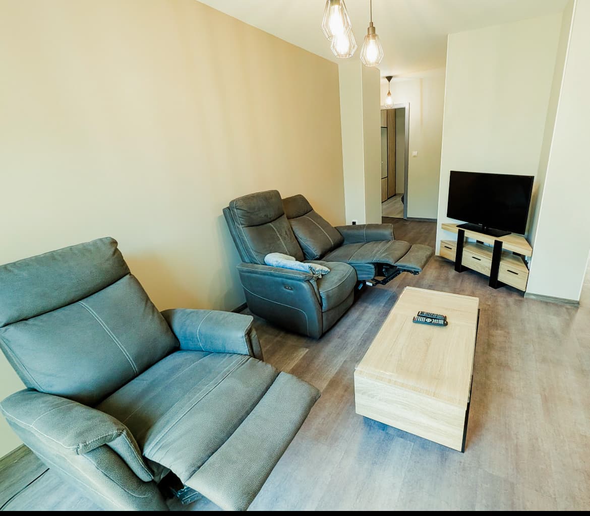 Salon avec fauteuils relax et télévision