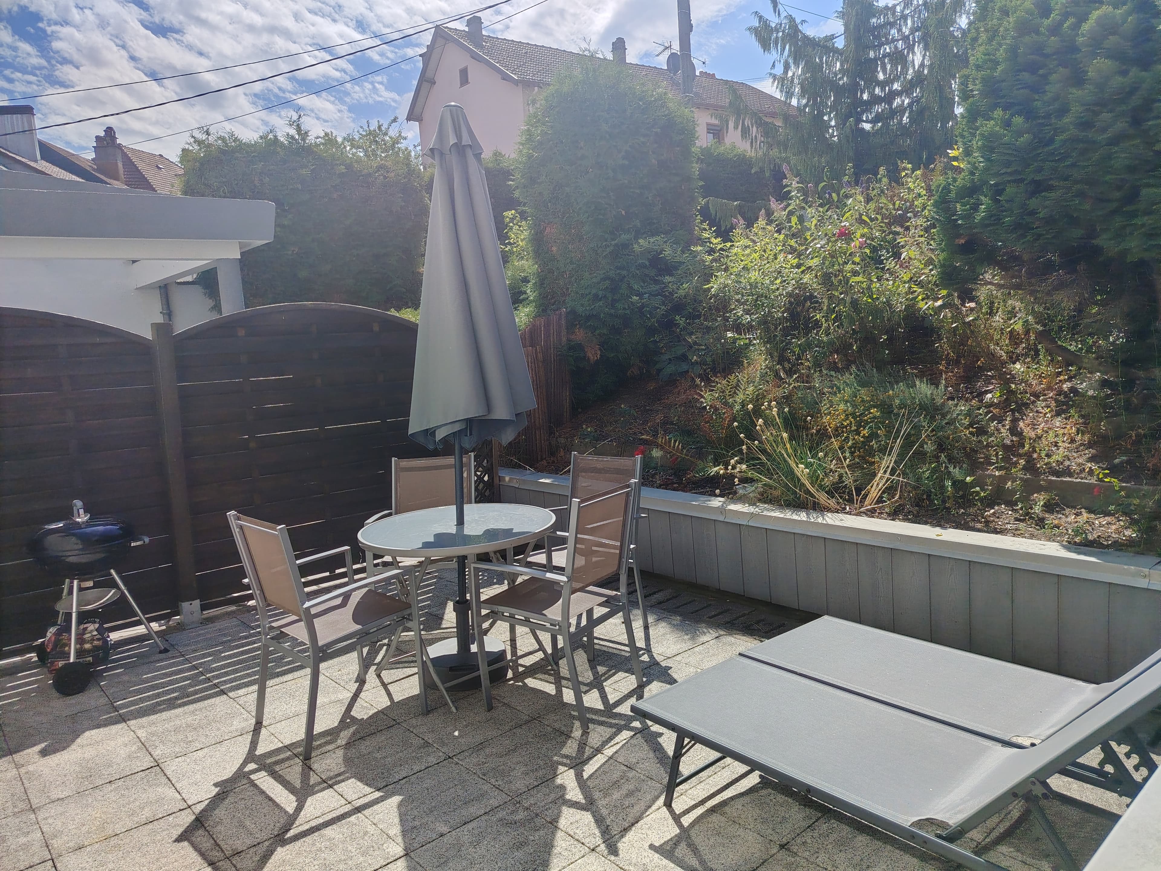 Terrasse privative avec mobilier de jardin et barbecue